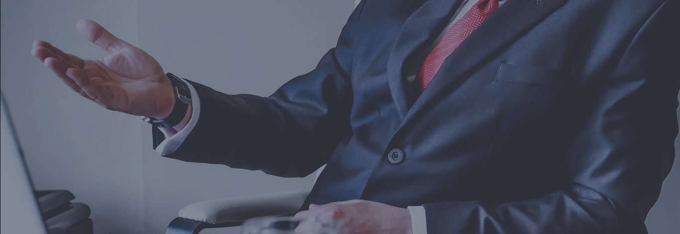Business professional in a suit gesturing during a commercial lending discussion